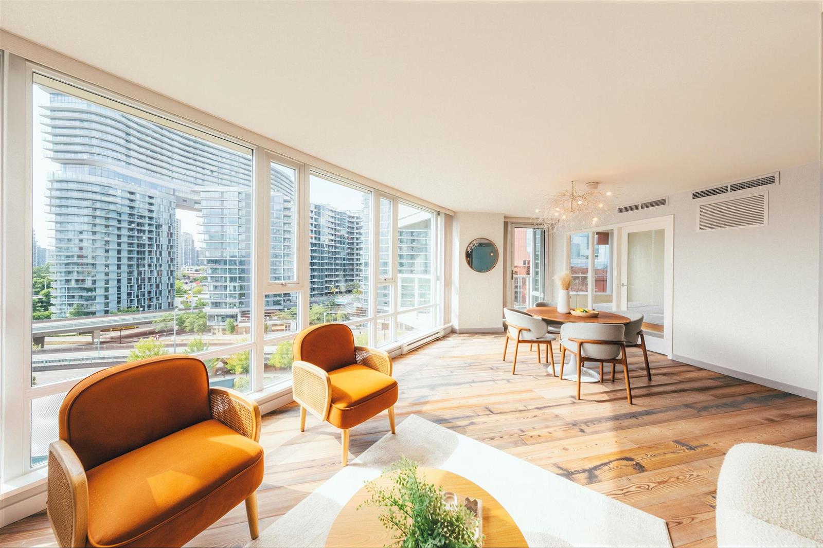The living room across the seating, the windows wrapping the corner and the dining area beyond.