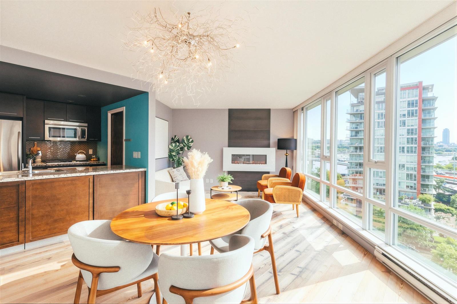 The dining table and the kitchen behind it, wood cabinets against the teal wall and the towers in the glass.