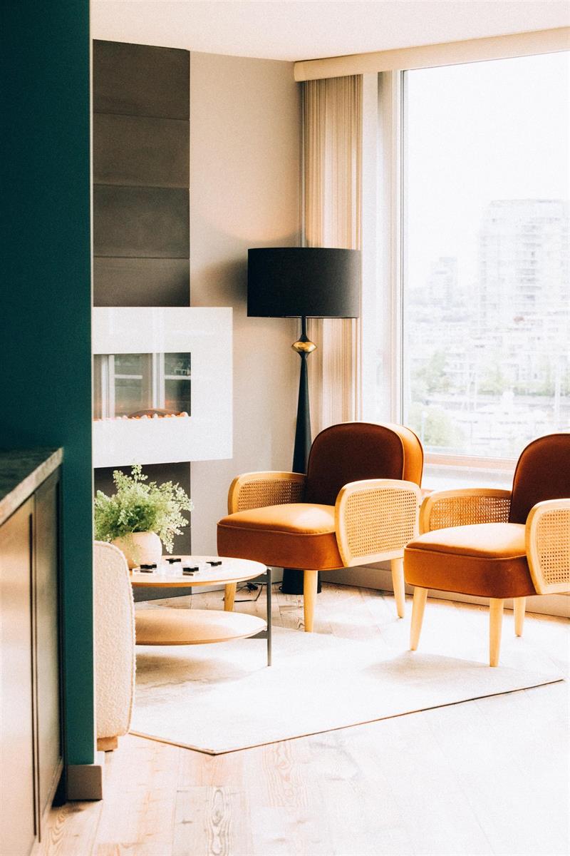 The corner by the fireplace, a lamp and two chairs with the city filling the window.