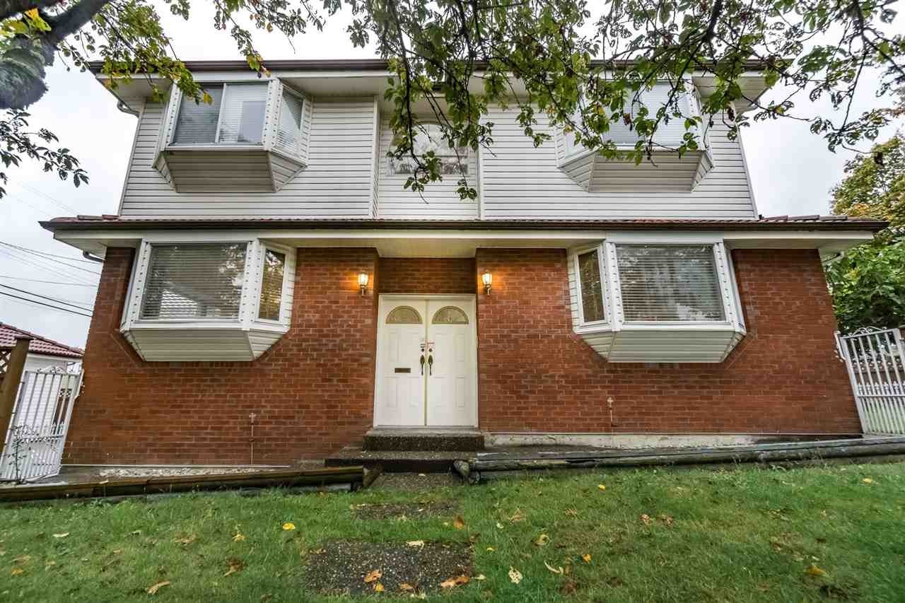 The front of the house, brick either side of the double entry doors with the bay windows above.