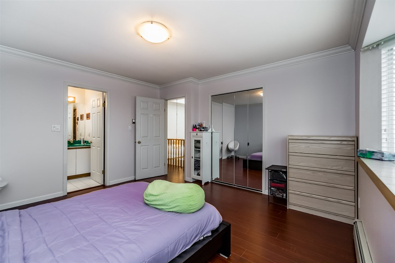 The bedroom toward the closet, the bed at the window and a chest of drawers beyond.