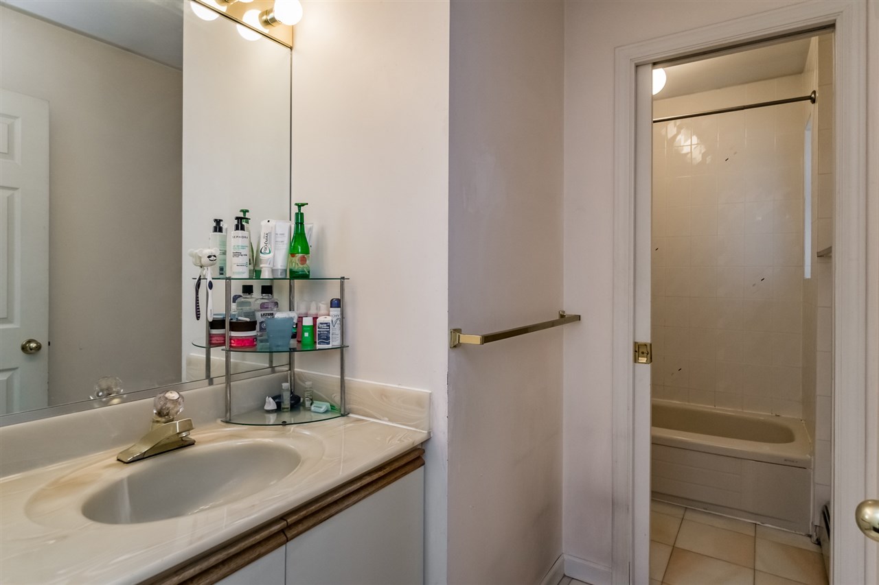 A bathroom below, a vanity and mirror with the door through beside it.