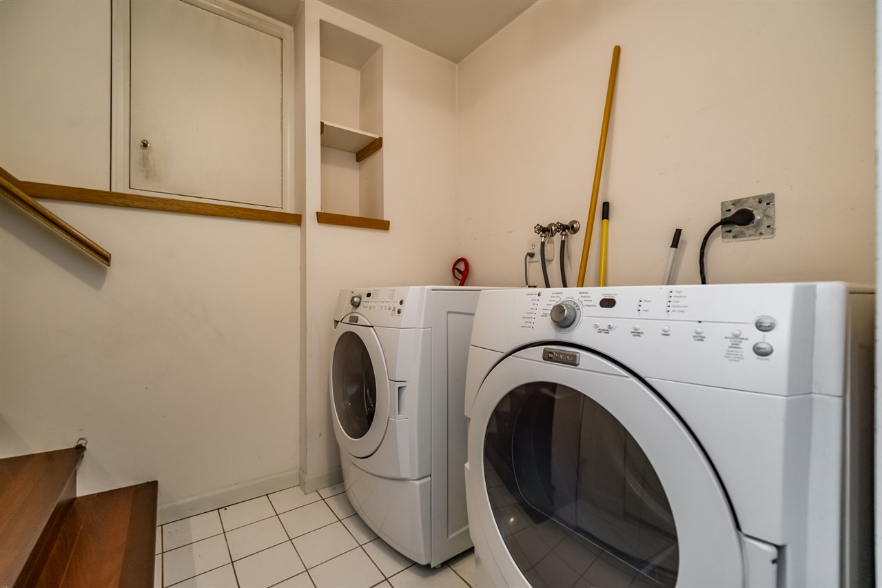 The laundry room, the washer and dryer side by side under the shelving.