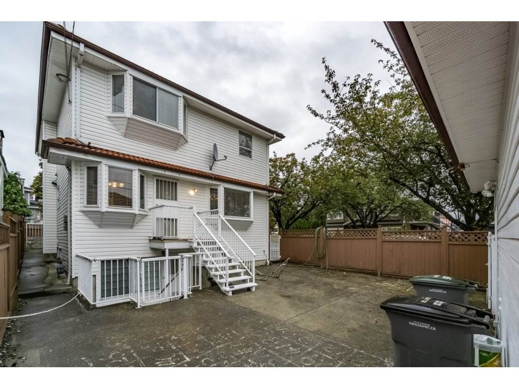 The back of the house, the stair up to the deck with the parking pad in front of the garage.