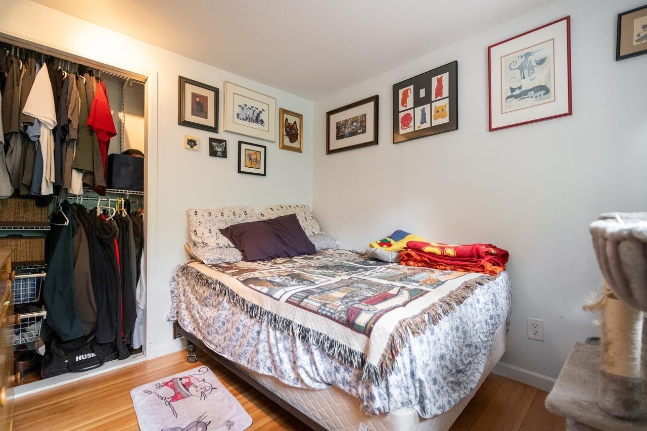 The second bedroom, a bed along the wall with a hanging rail beside it.