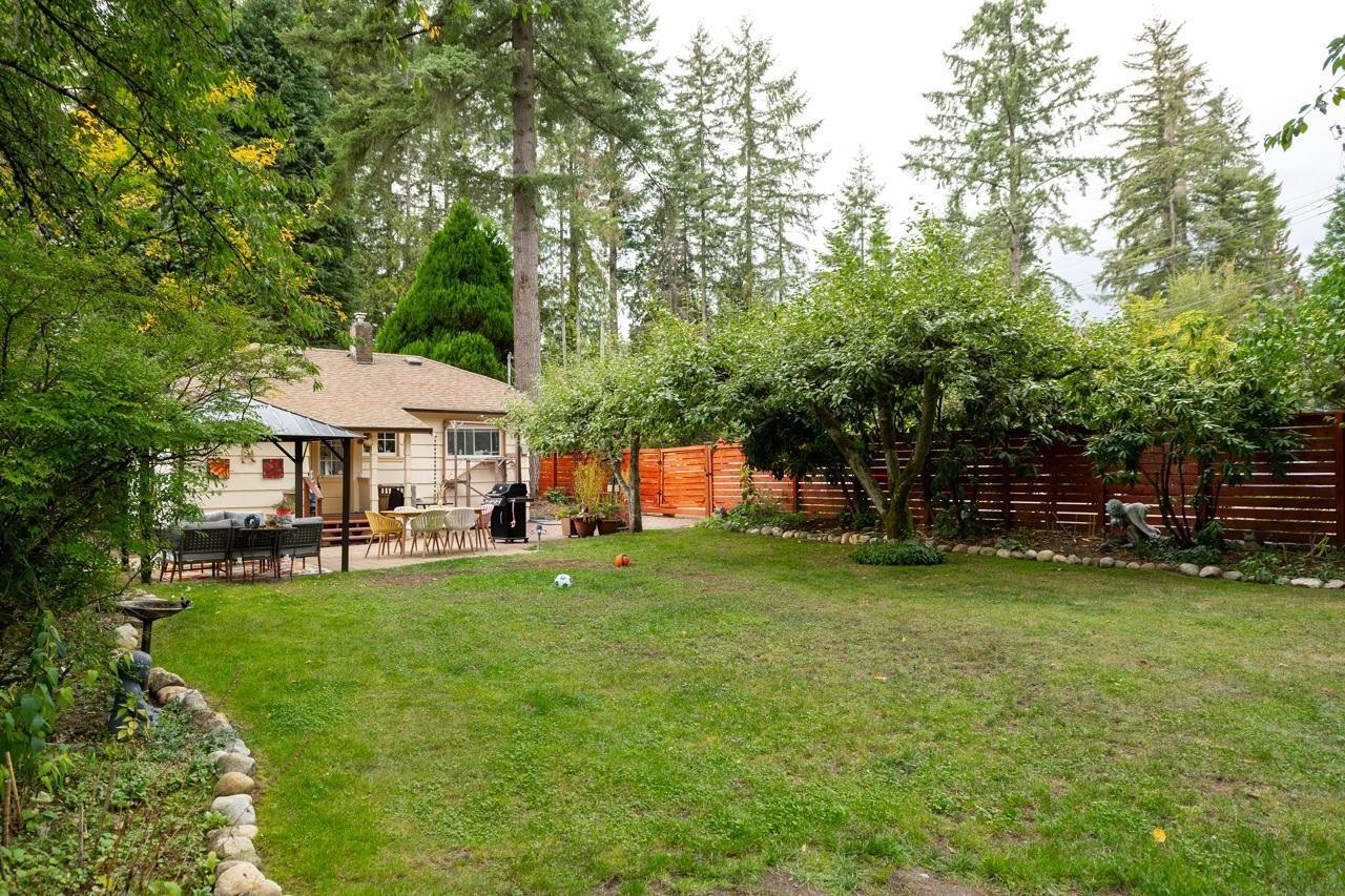 The back garden, a wide lawn with the house and its gazebo along the far side.