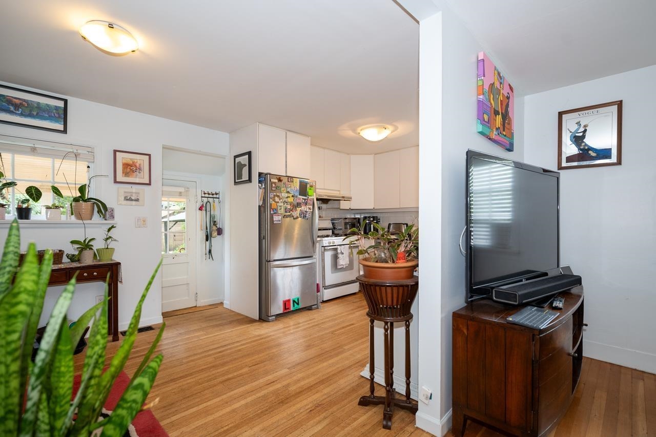 Looking from the living room into the kitchen, the fridge and range along the far wall.