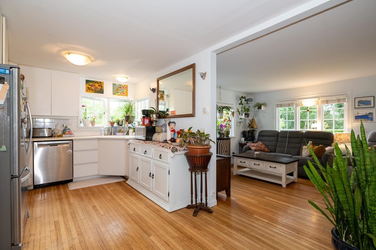 The kitchen from the living room side, dishwasher and range in a row under the upper cabinets.