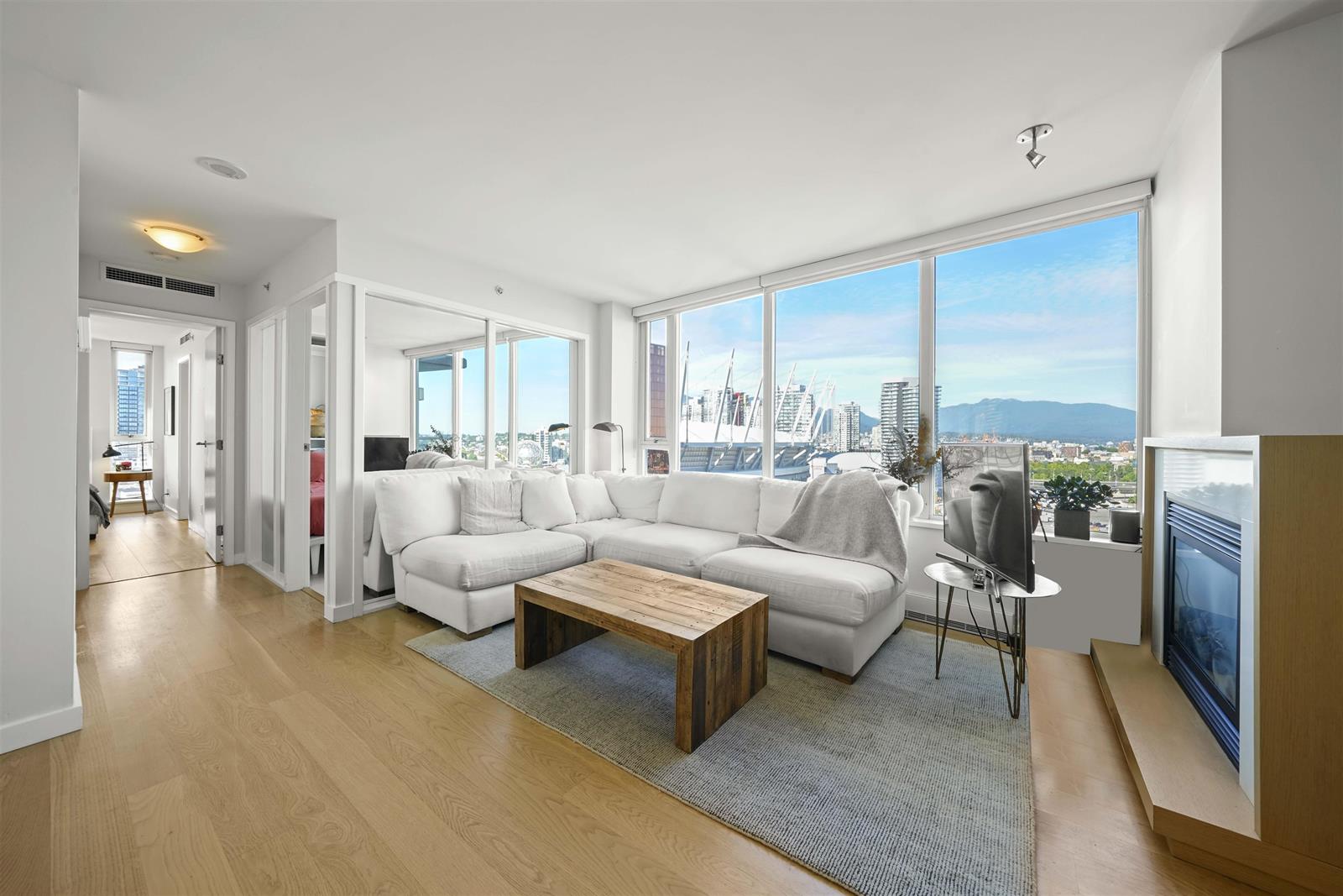 The living room in the corner of the plan, windows on two sides looking out to the water and the city.