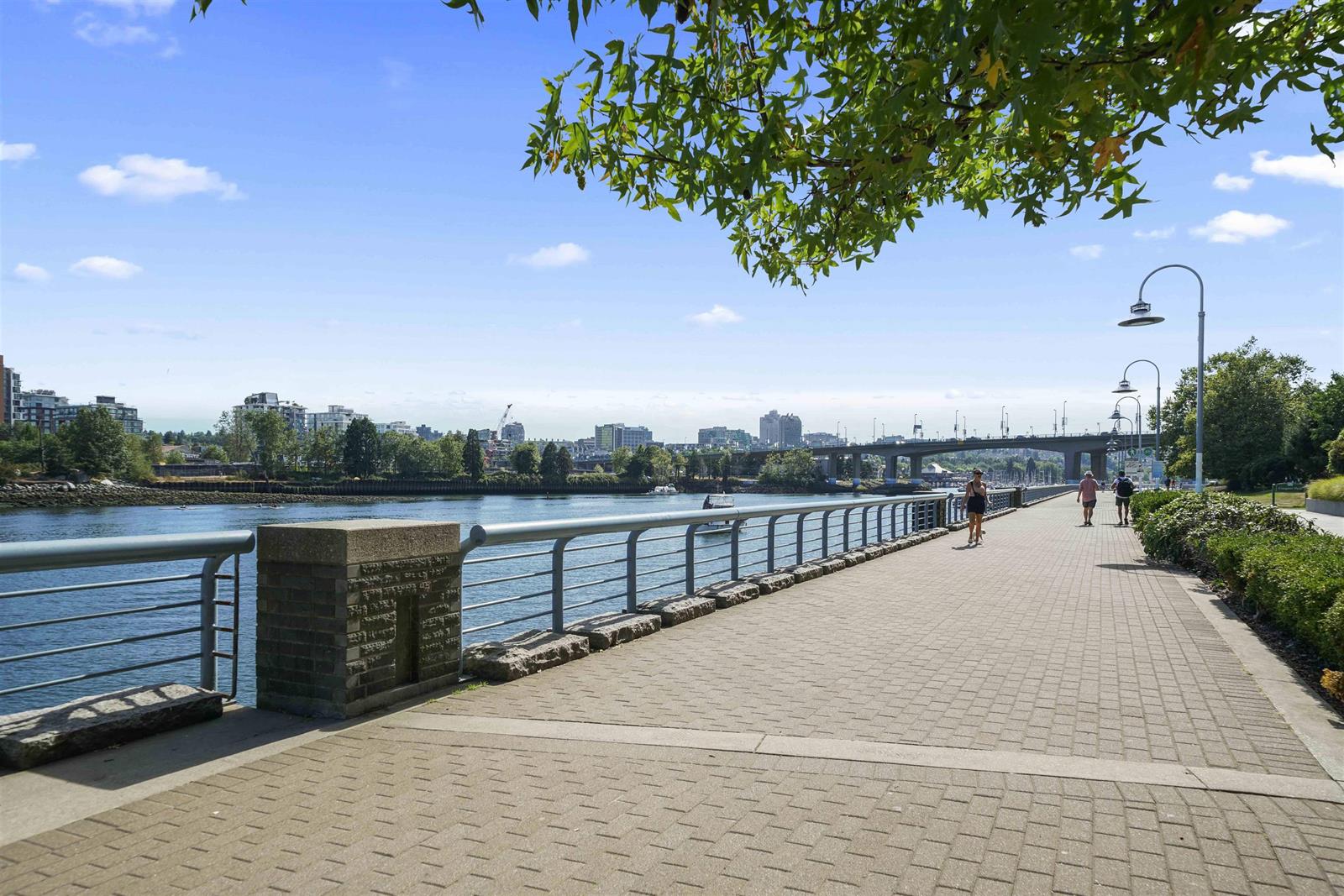 The seawall below the building, the path running along the water towards the city.