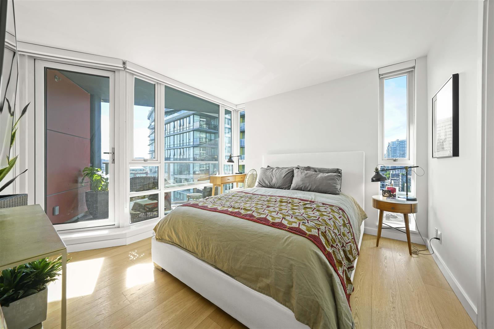 The main bedroom, a door out to the balcony beside the bed and the towers past it.