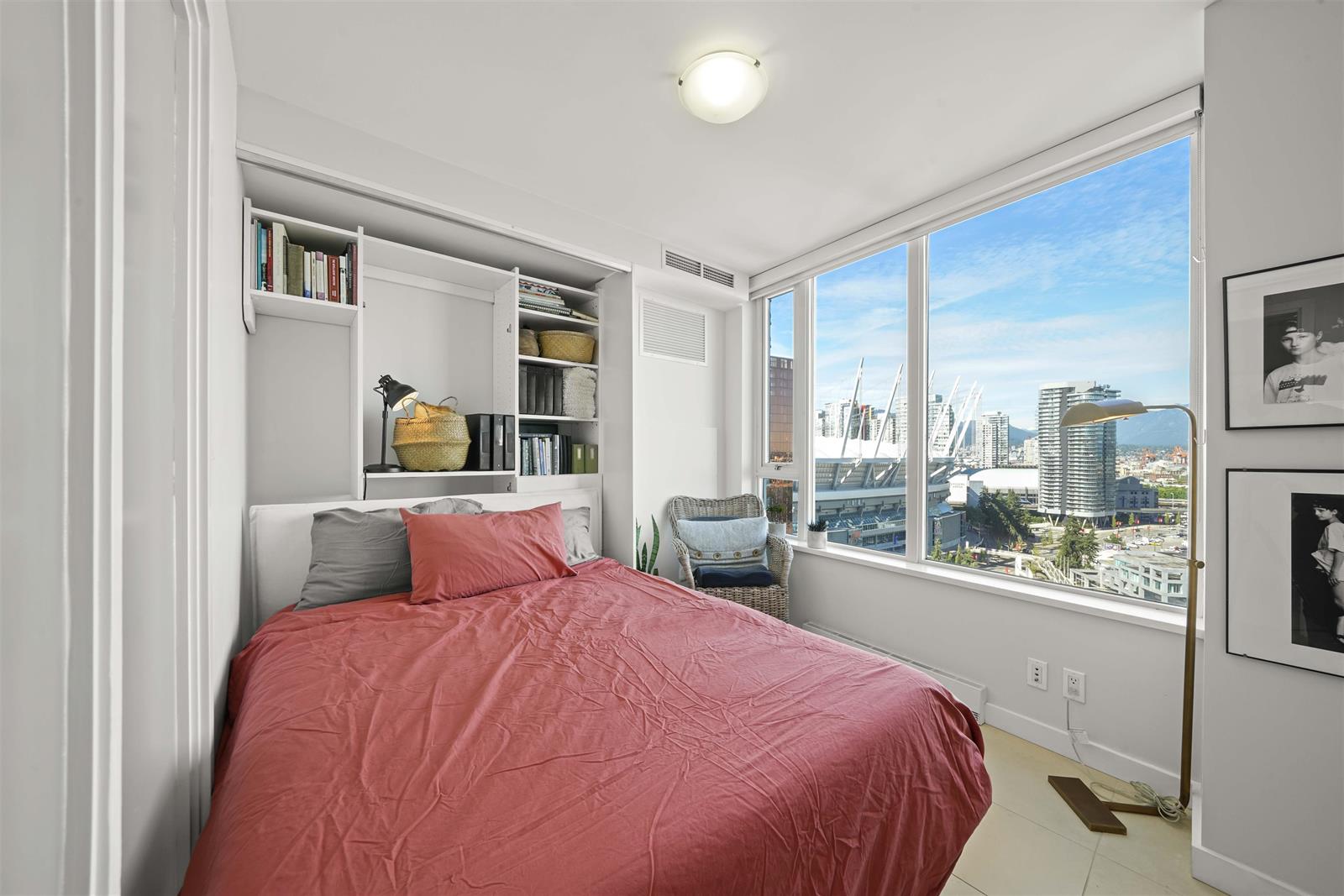 The second bedroom, shelves built in beside the window and the city beyond it.