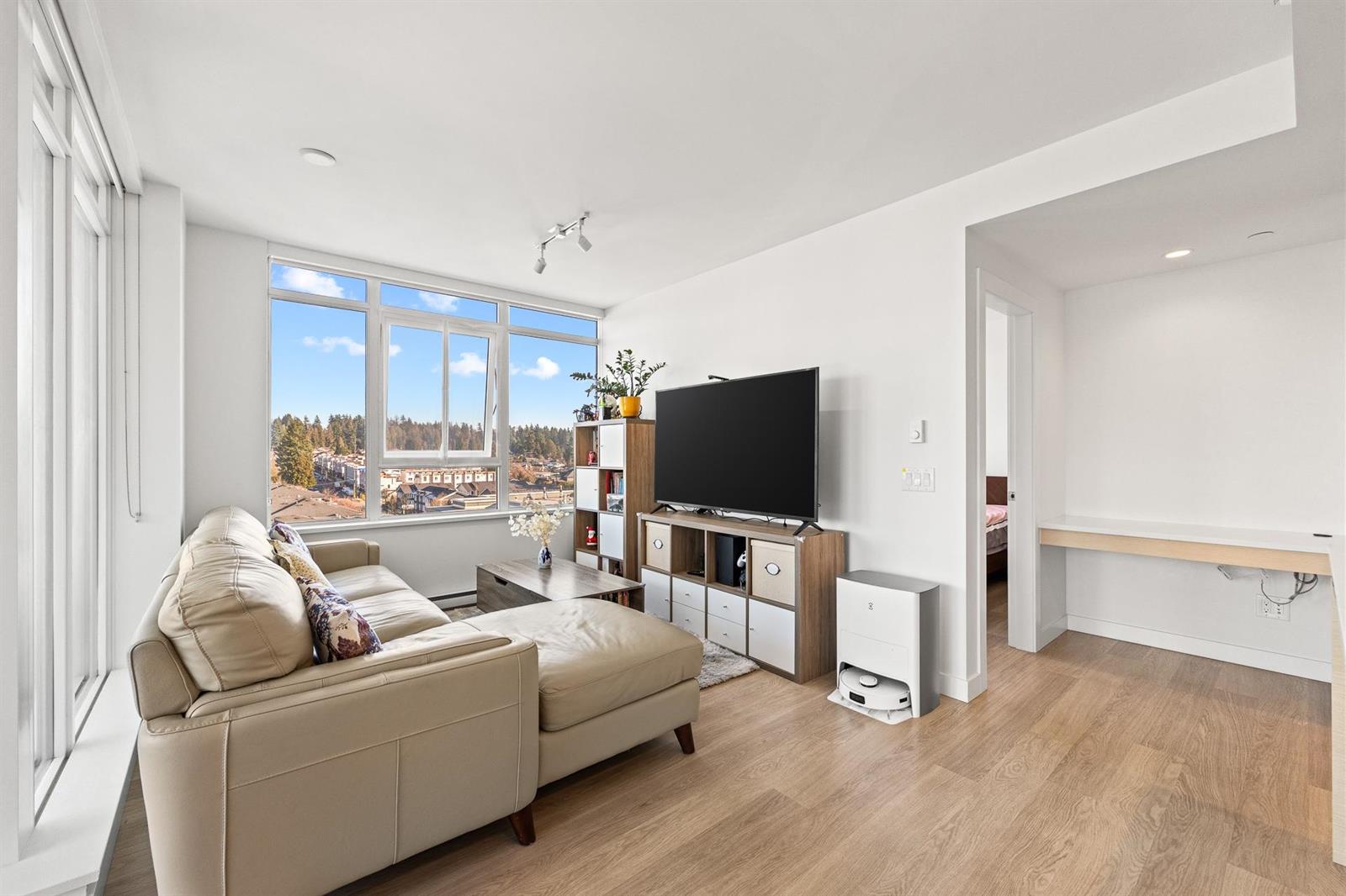 The living room from the dining end, sofa and television along the wall.