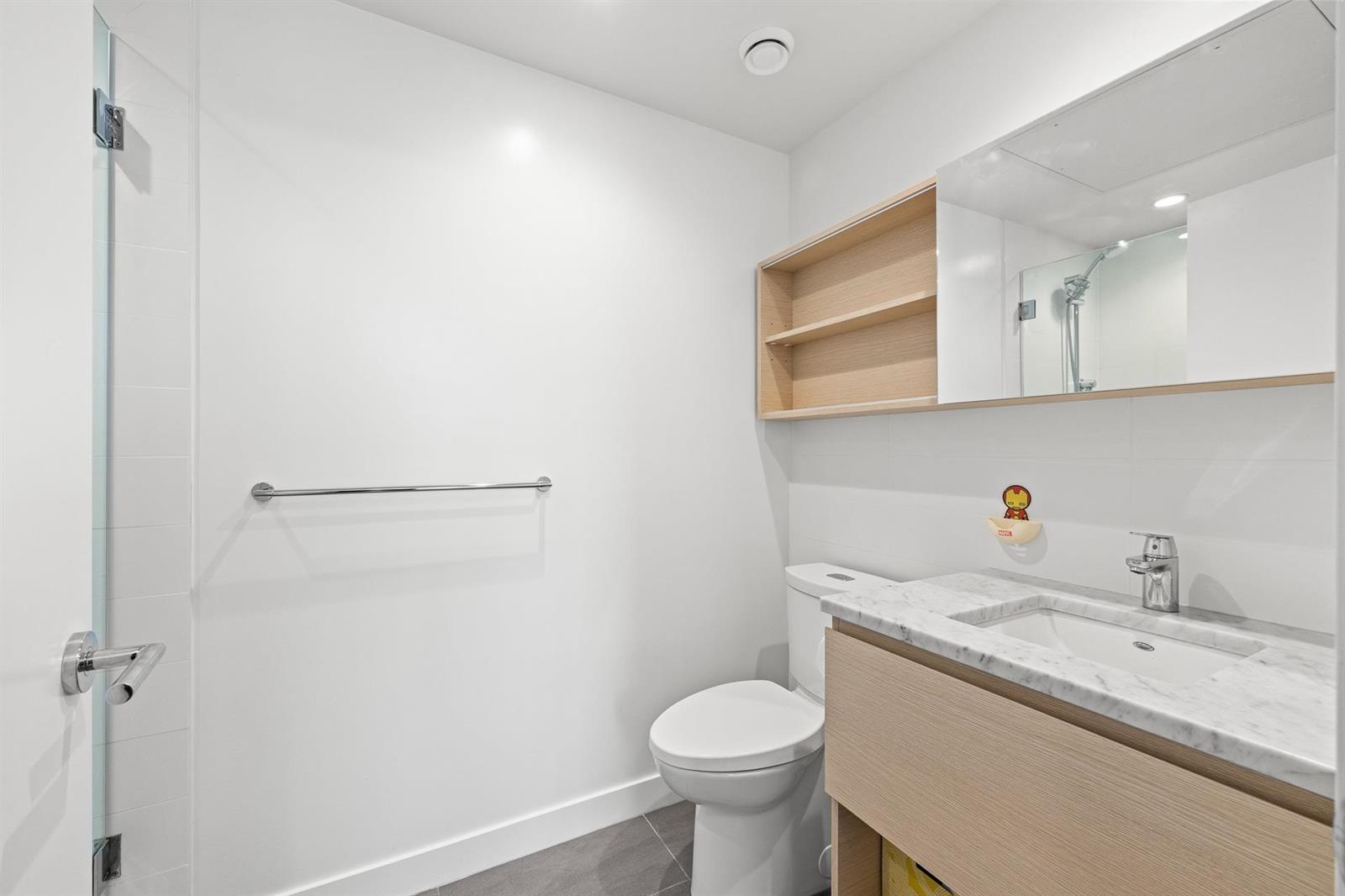 The ensuite, a vanity and mirror with open shelving above.