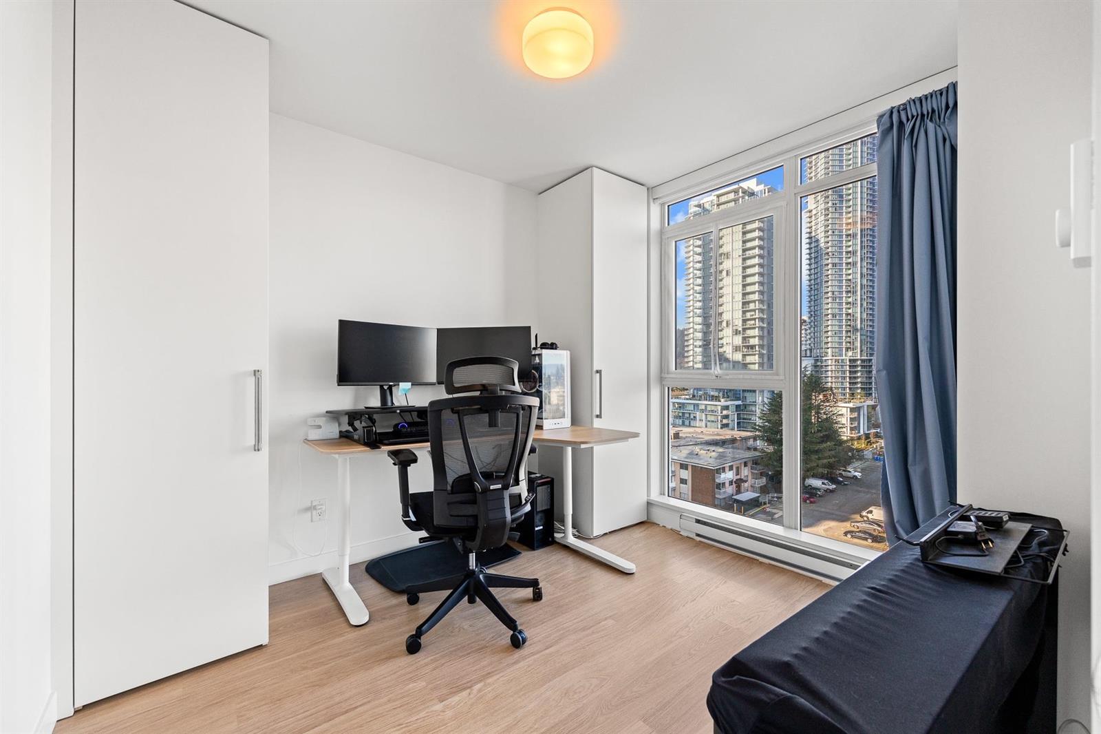 The second bedroom used as a study, a desk at the corner window.