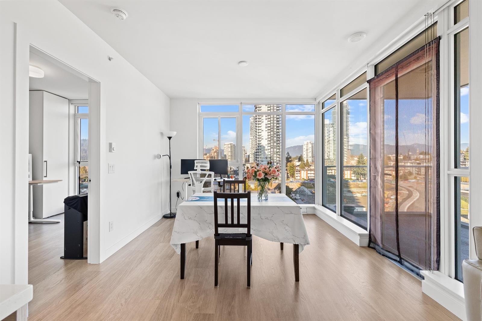 The dining area in the corner, a table and chairs against windows on two sides.
