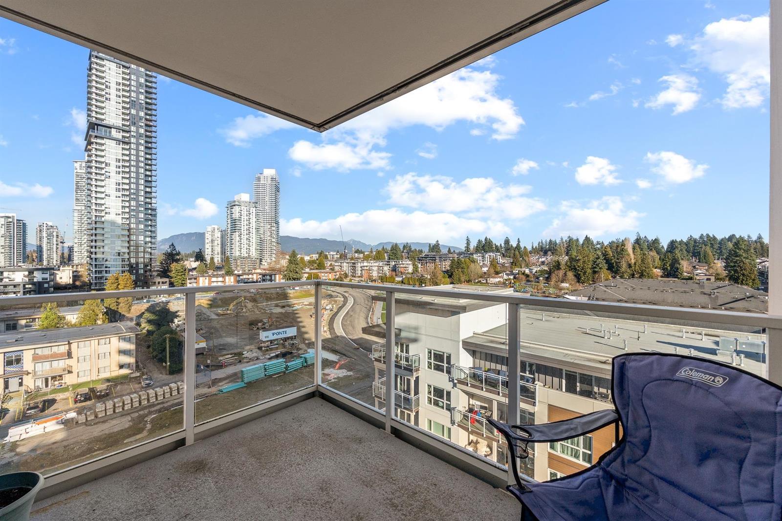 The balcony, a chair by the rail with the mountains in the distance.