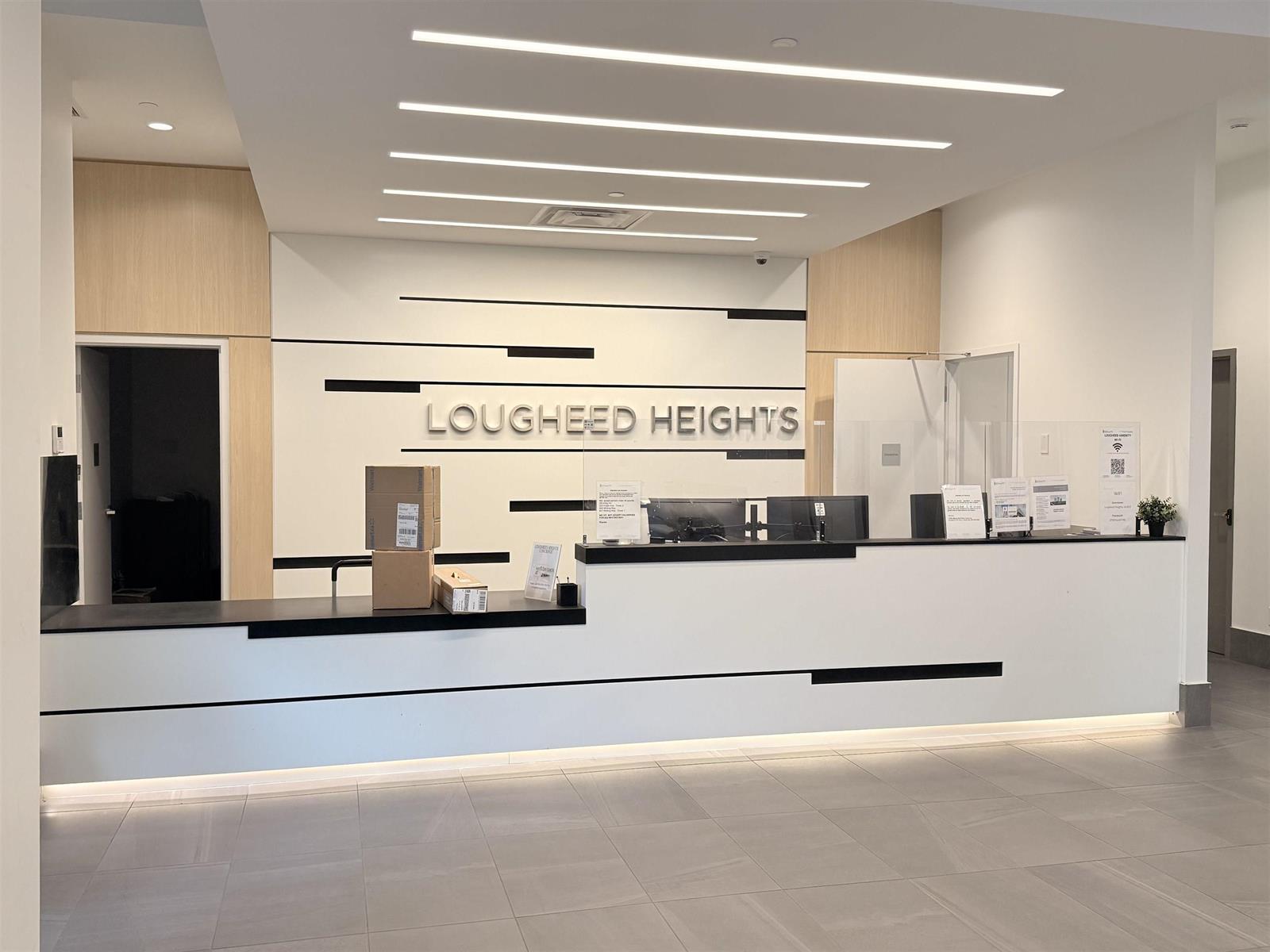 The concierge desk, Lougheed Heights lettering on the wall behind.