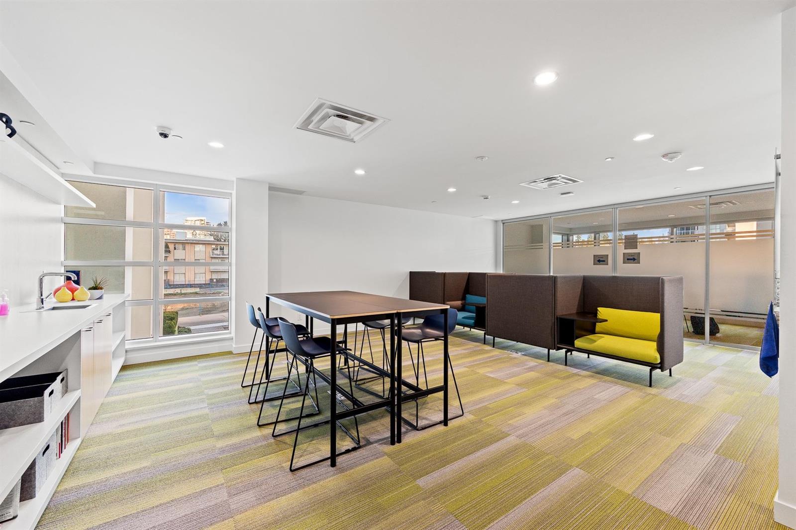 The business centre, a long table with stools and a lounge beyond.