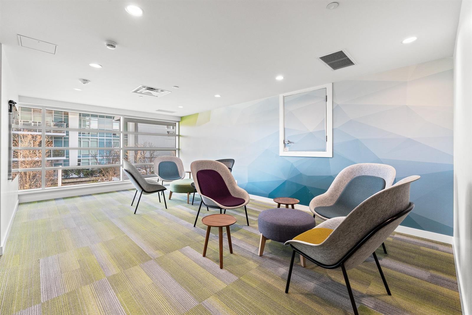 A lounge off the amenity floor, armchairs against a painted wall.
