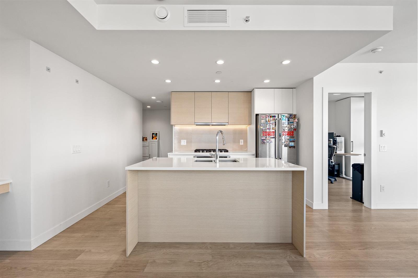 The kitchen island from the living room, the entry hall beyond it.