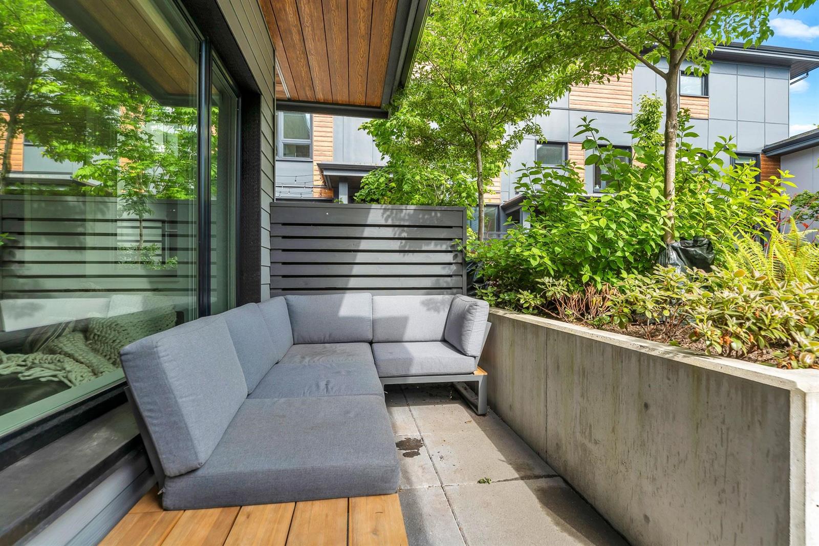The patio at the back, bench seating built in against a planted wall.
