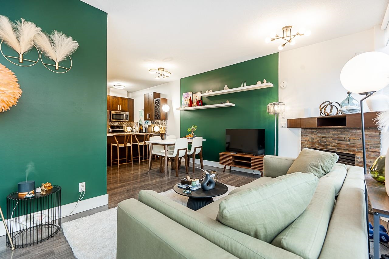 The dining end of the room, a run of white shelves on the green wall and the kitchen stools beyond.