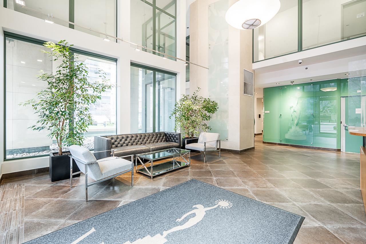 The lobby of the building, a double-height space in glass and stone with seating.