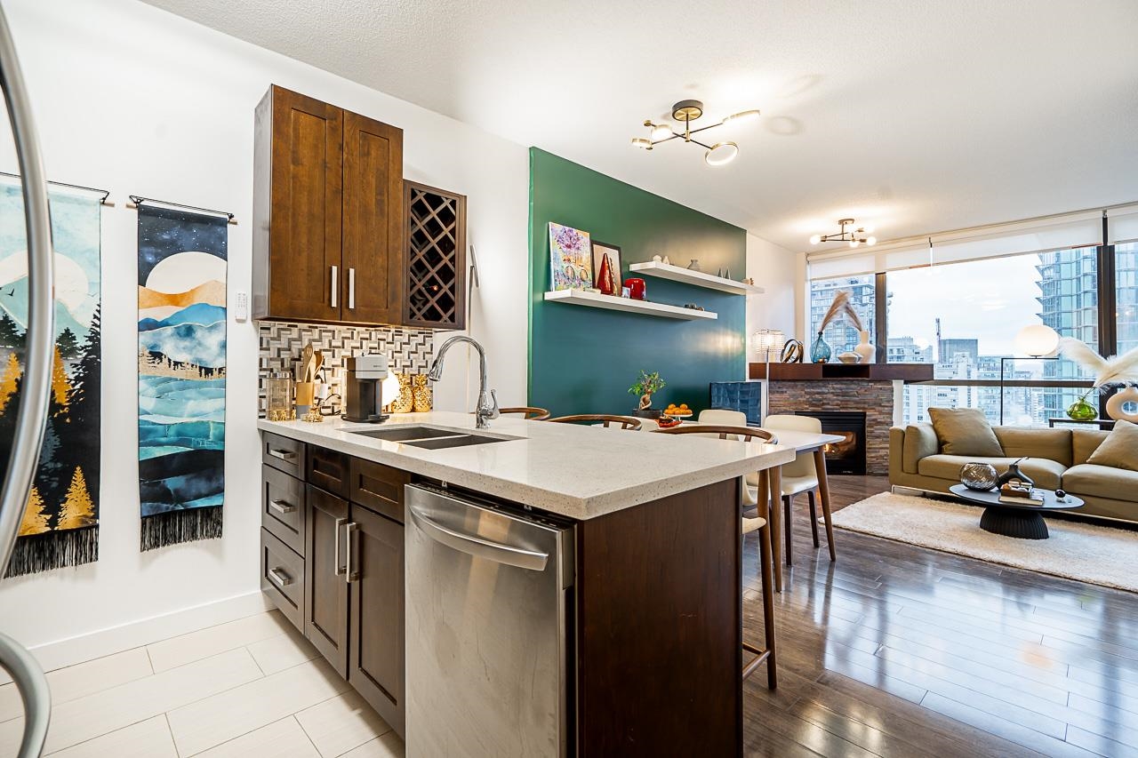 The kitchen island and dark cabinetry from the living room side, the city out the window beyond.