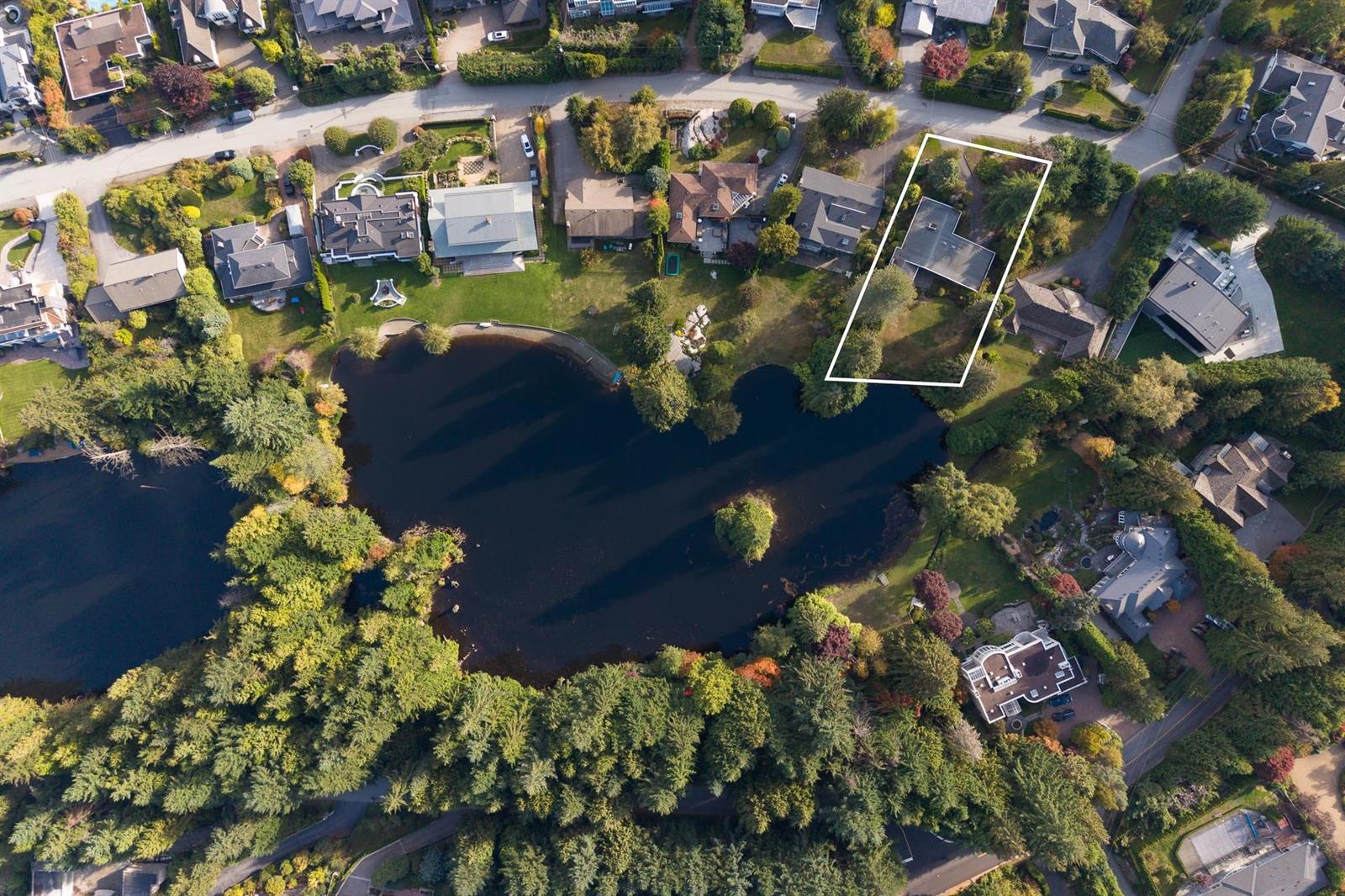 An aerial view looking down on the lake and the sixteen homes around it.