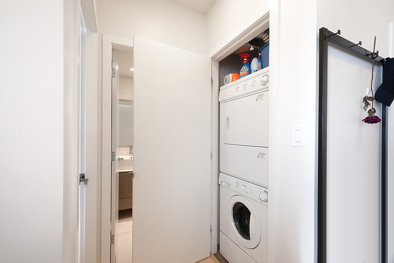 The hall, the bathroom door on one side and the stacked washer and dryer in their closet on the other.