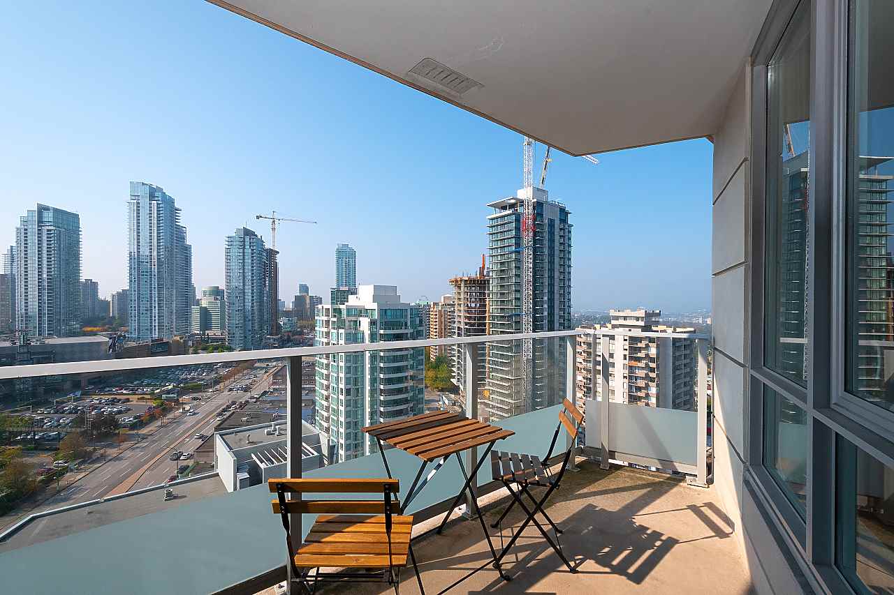 The balcony, a small table and two chairs at the rail with the towers along the far side.