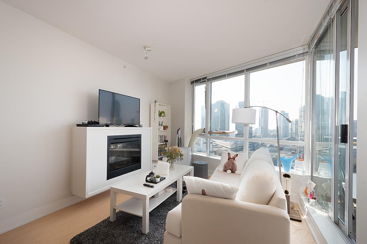 The living room toward the glass, a sofa and a low table with the window wall running the length of the room.