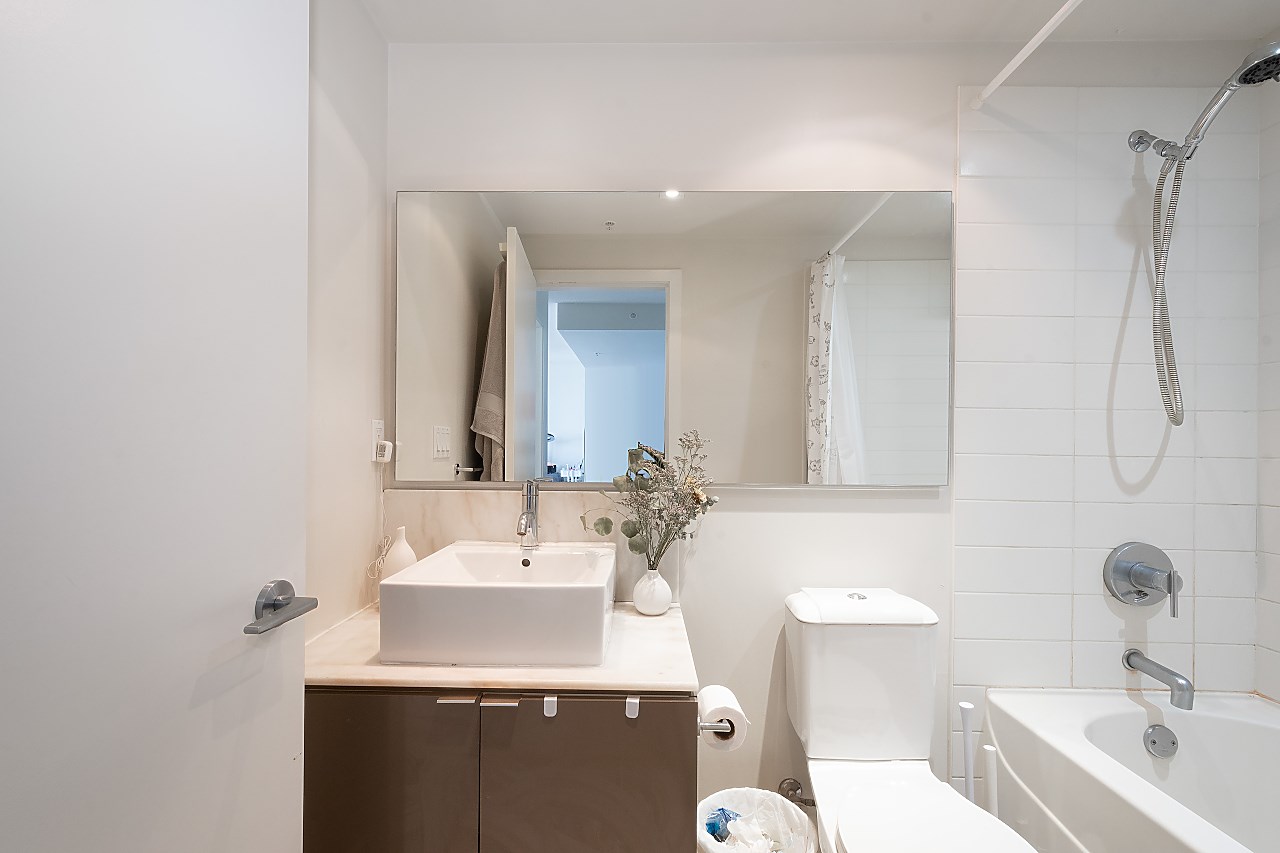 The bathroom, a vessel basin on a timber vanity with the tub and shower behind.