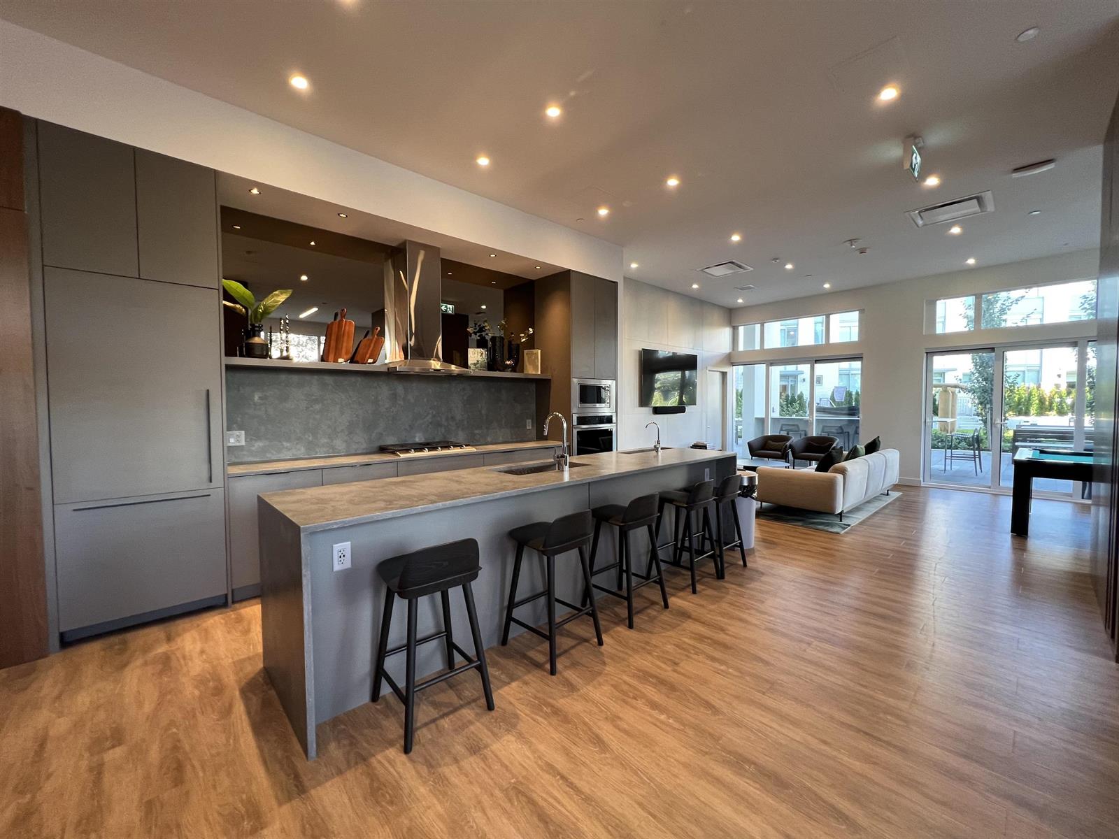 The building's social lounge — a long island with stools along it, and seating beyond.