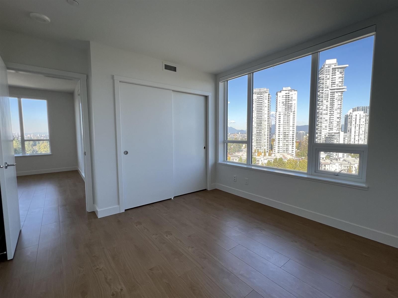 The second bedroom, a closet along one wall and a window out to the towers.