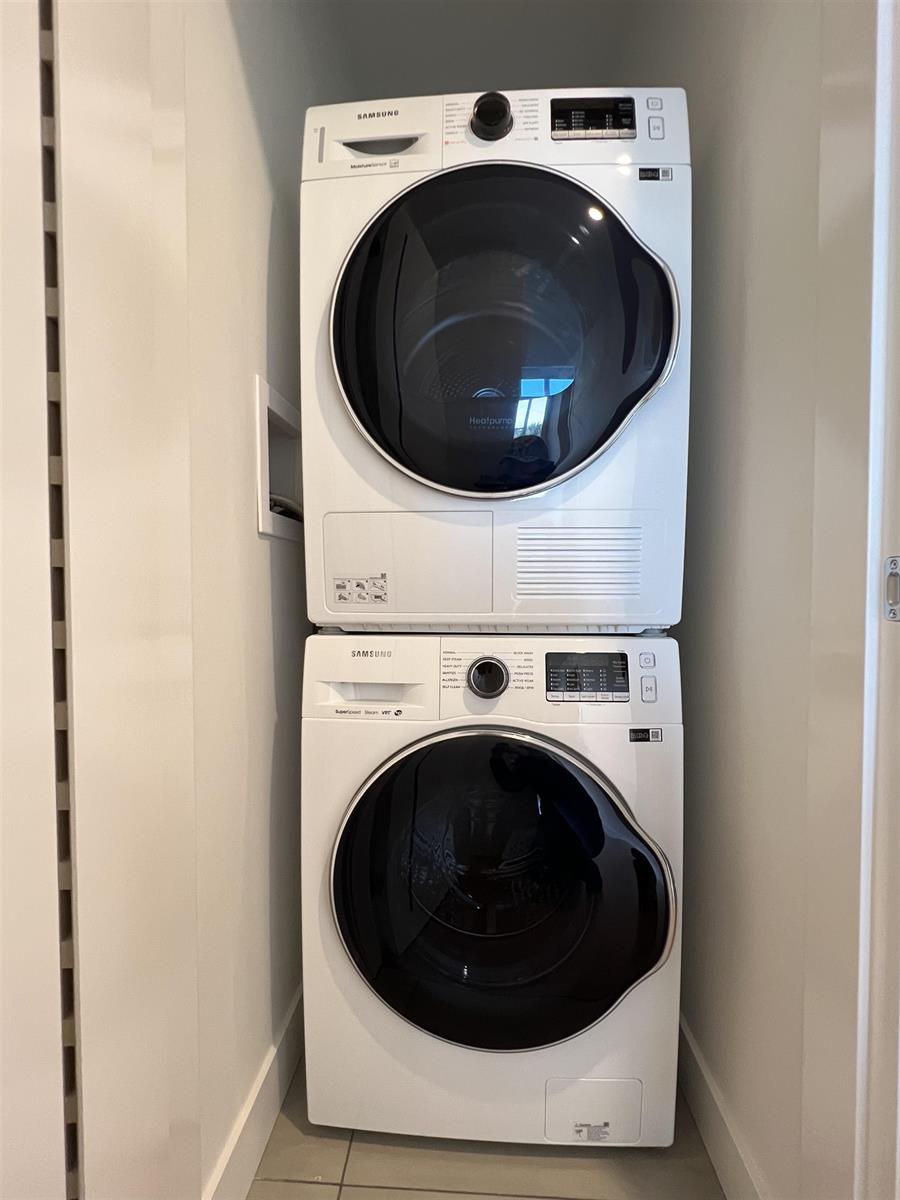 The laundry, a washer and dryer stacked in their own cupboard.