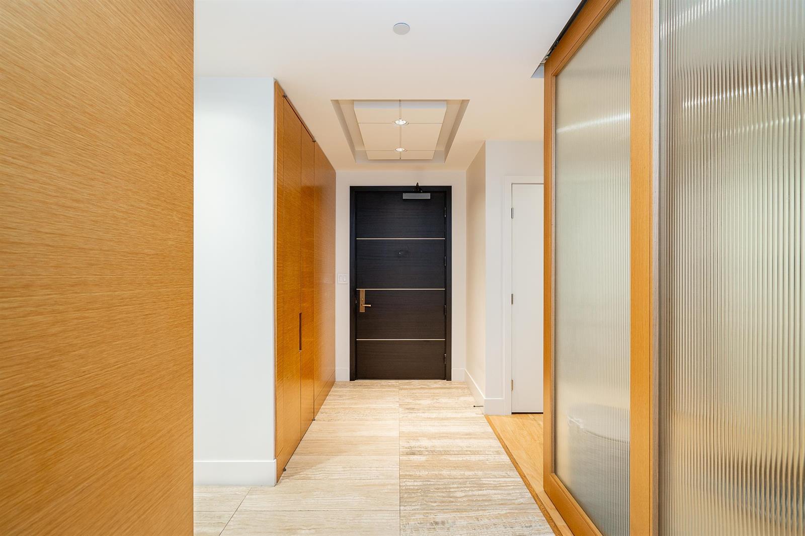 The entry hall, wood panelling on both sides leading to the suite door.