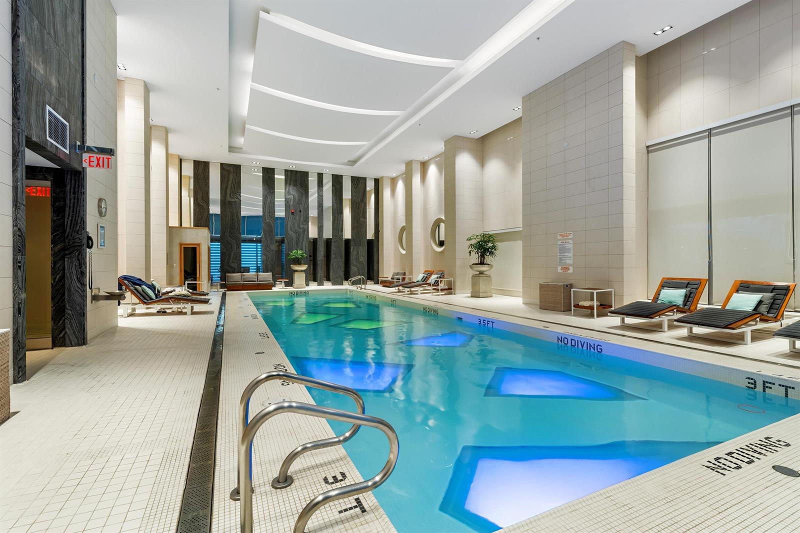 The indoor saltwater lap pool, loungers along one side beneath a curved ceiling.