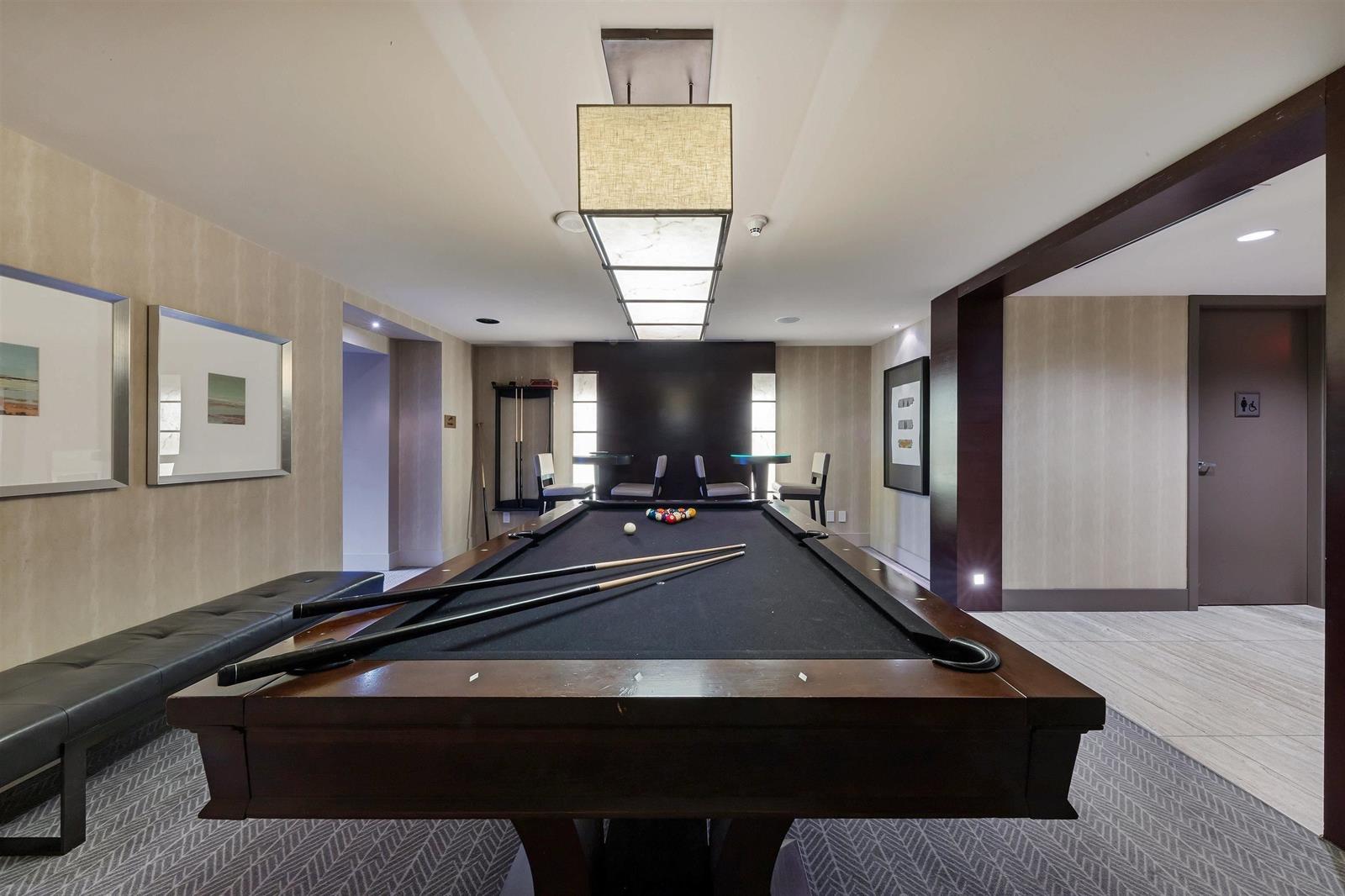 The games room, a billiard table under a large pendant light.