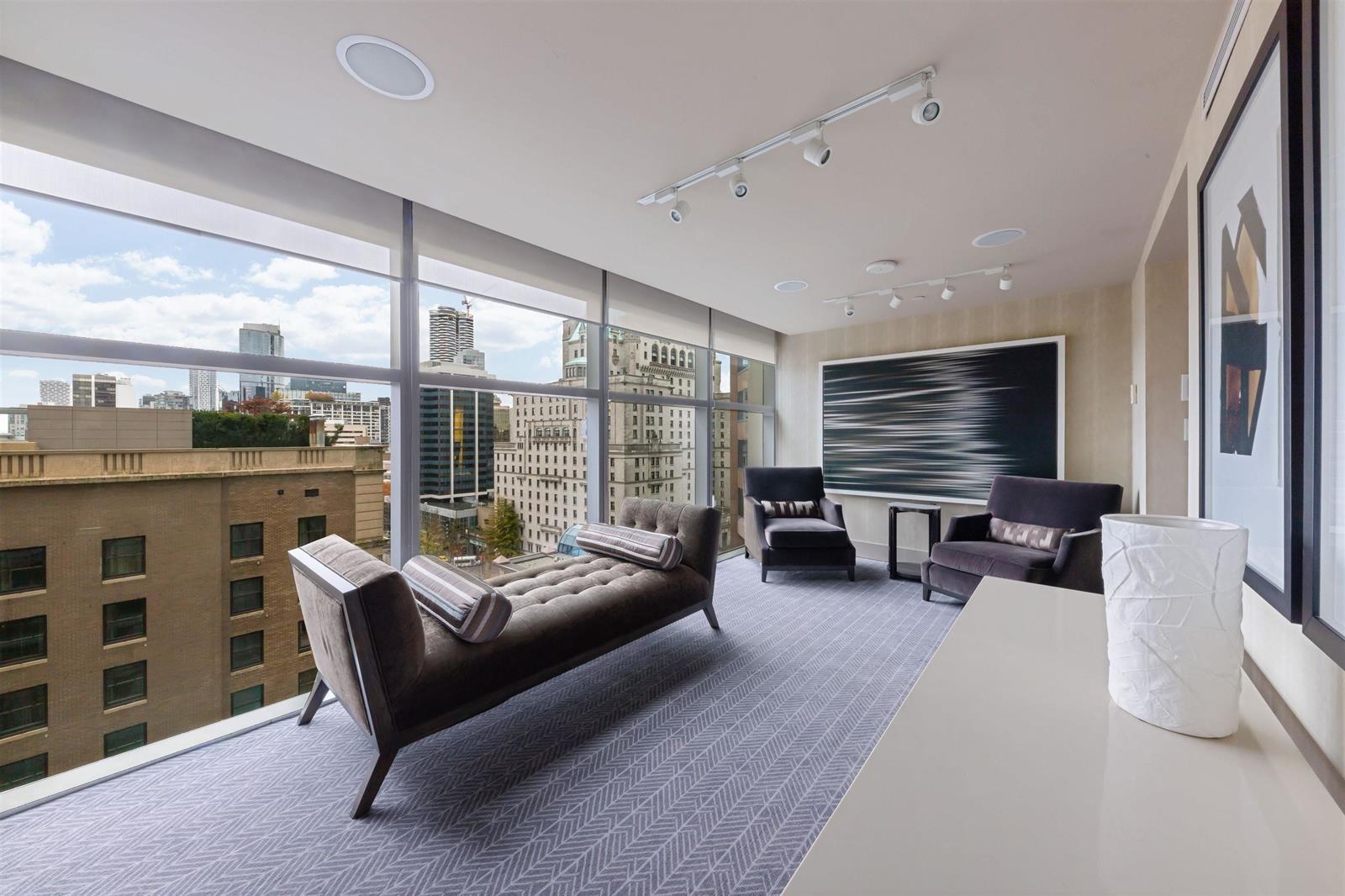 The residents' lounge, a bench and seating group beside windows looking onto the city.