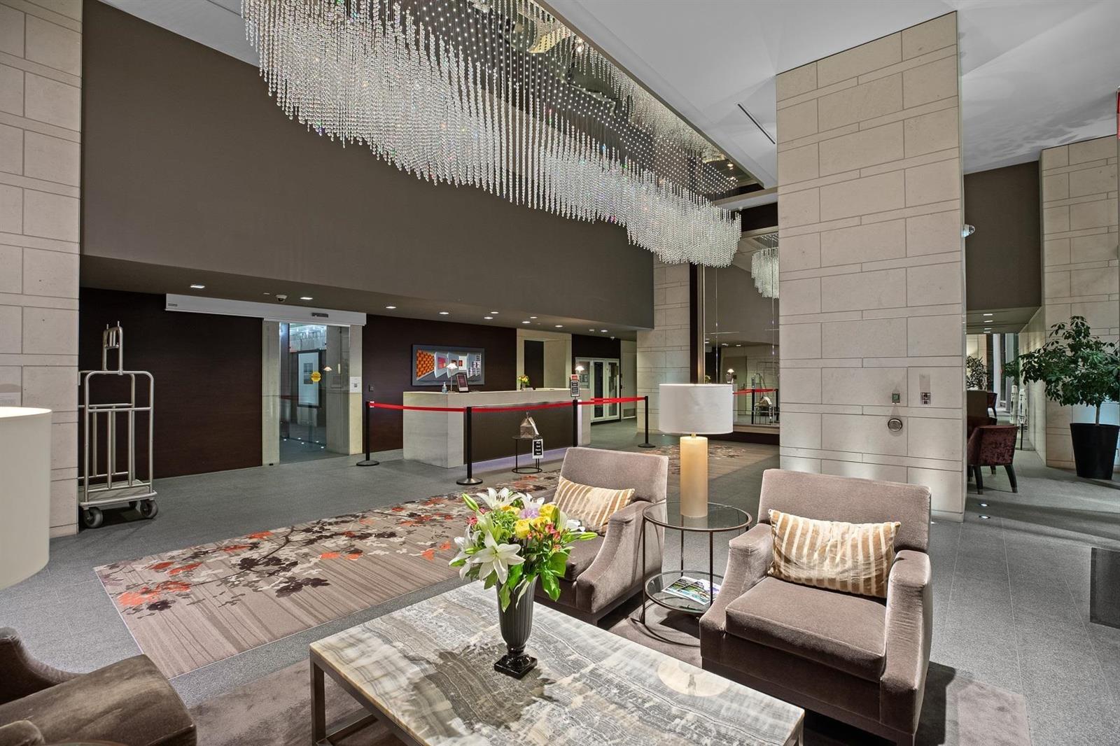 The lobby, a chandelier above the seating with the concierge desk beyond.