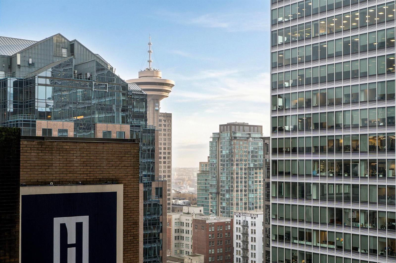 The view from the windows, west across the older rooftops of the block toward the towers and the harbour beyond.