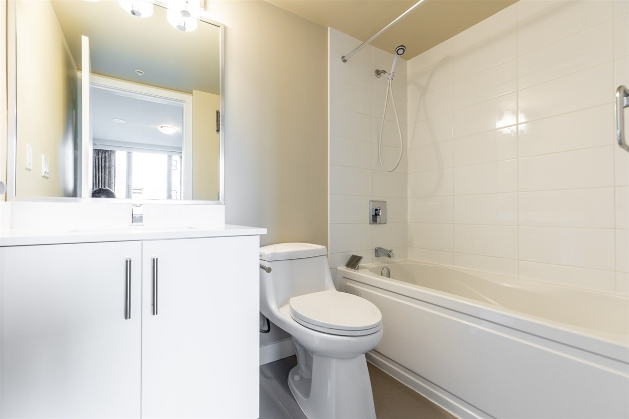 The ensuite, a tub and shower beside the vanity and mirror.