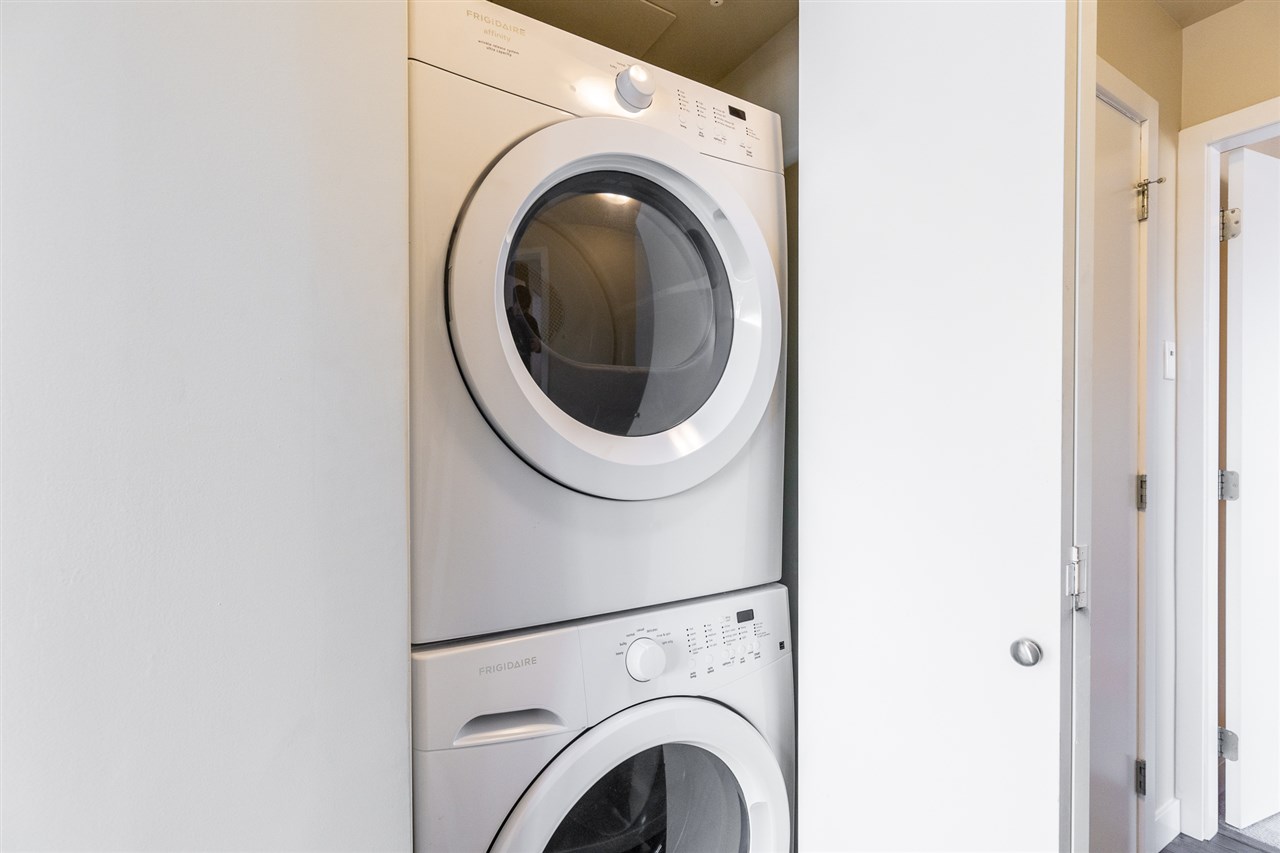 The in-suite laundry, washer and dryer stacked in their own closet.