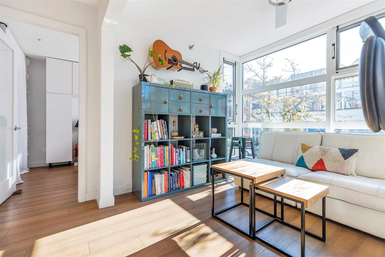 The same corner from the living room, bookshelves along the wall and light coming in.