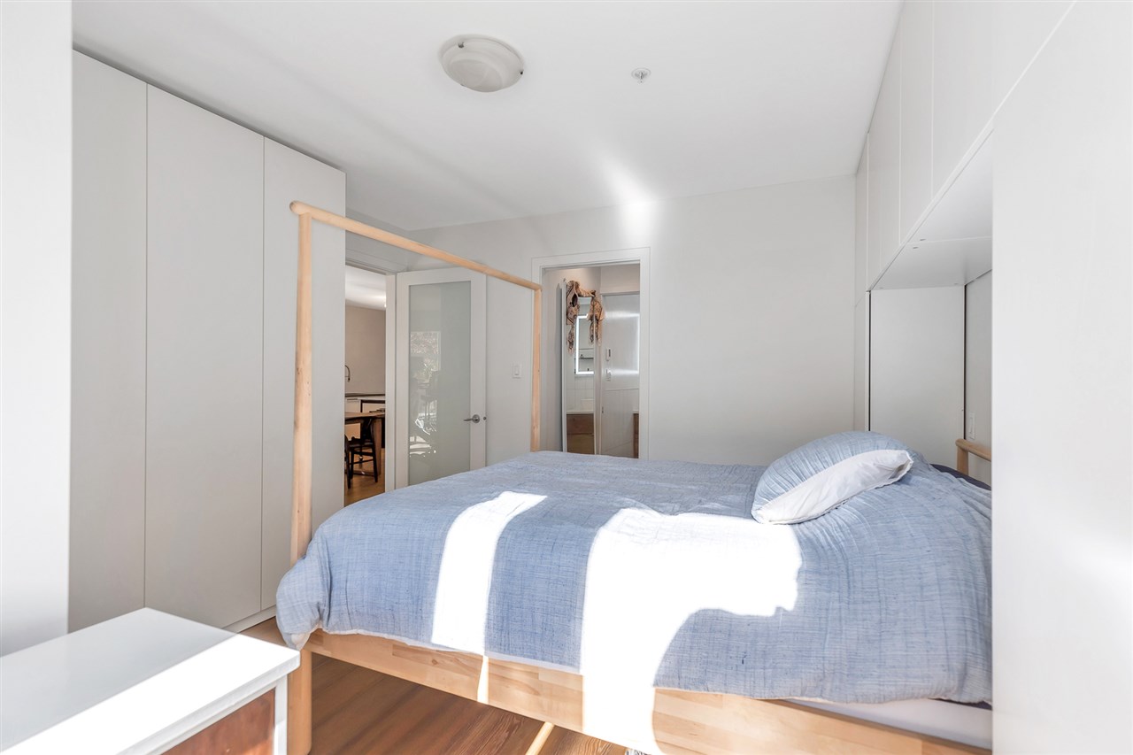 The primary bedroom from the far corner, wardrobes along one wall.