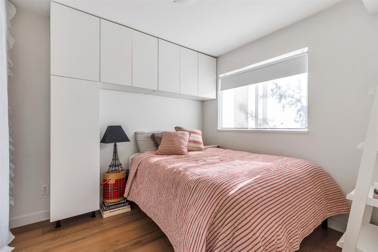The second bedroom, cabinetry above the bed and a window to the side.