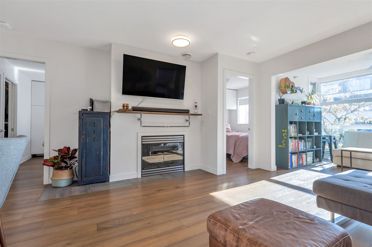 The living room fireplace, a television above the mantel and the bedroom door beside it.