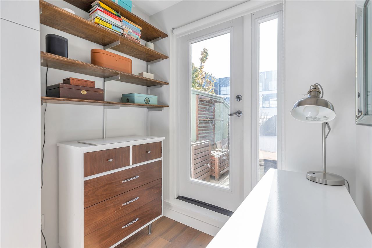 The shelving beside the patio door, a chest of drawers below it.